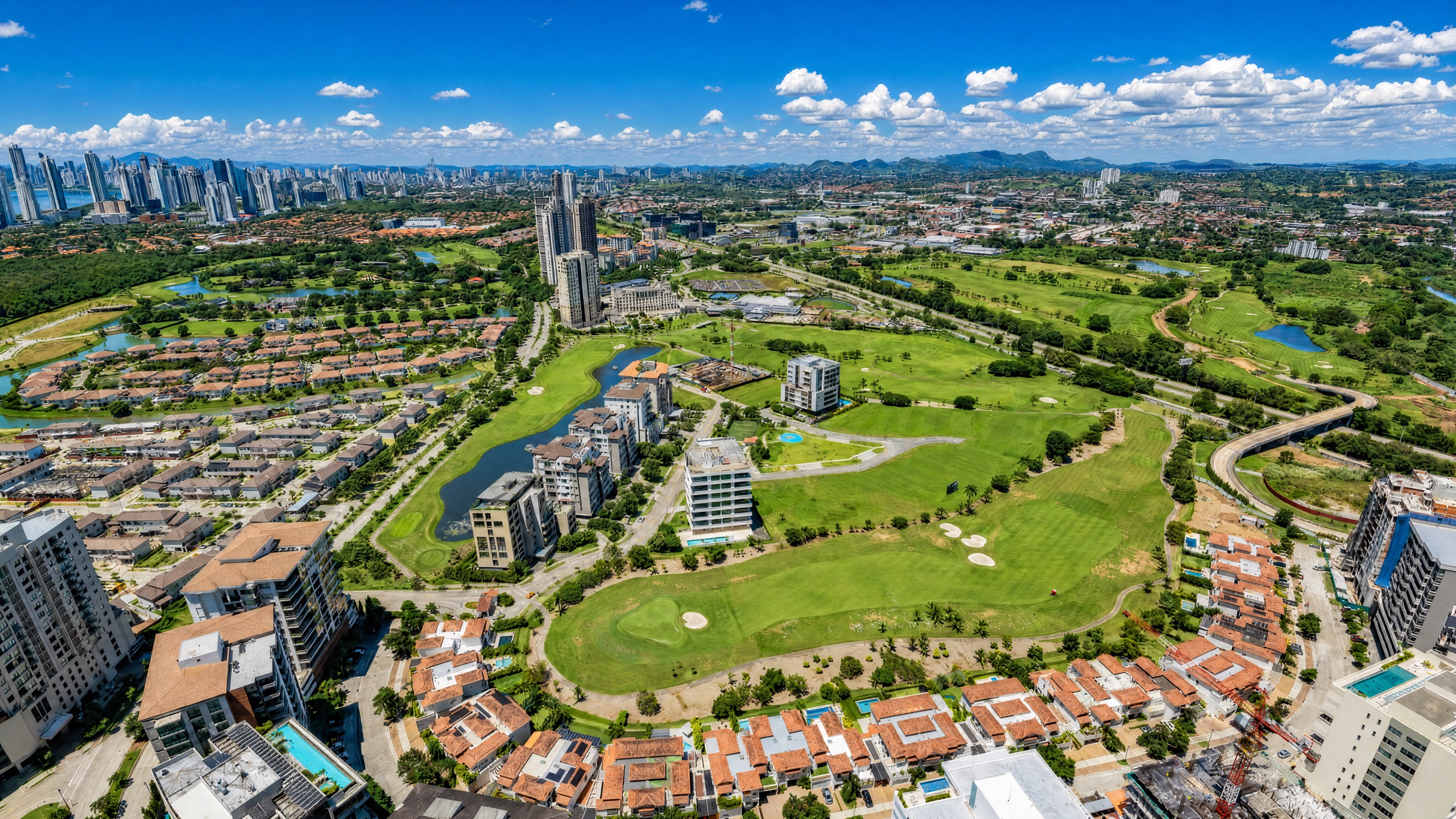 Santa Maria Golf and Country Club district in Panama City, manicured fairways and water features framed by upscale low-rise apartment buildings and villas with tropical landscaping.